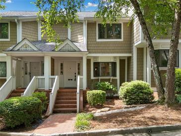 Inviting townhome exterior featuring a well-maintained facade, brick steps and mature landscaping at 6 Alston Place Ne Ne Pl, Atlanta, GA 30324