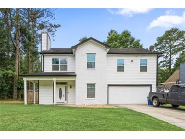 Charming two-story home featuring a covered porch, attached garage, and well-manicured lawn at 2670 Trotters Pointe Drive Dr, Snellville, GA 30039