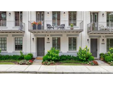 Charming townhome with white brick, a balcony, and a well-manicured front garden at 328 Stonemont Dr, Atlanta, GA 30305