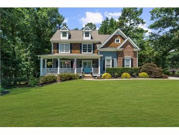 Charming two-story home with a manicured lawn, lush landscaping, and inviting front porch at 4020 High Gables E, Cumming, GA 30041