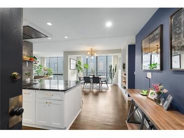 Bright, open kitchen and dining area with a modern island and large windows overlooking the city at 145 15Th Ne St # 826, Atlanta, GA 30309
