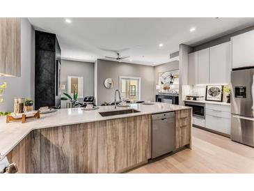 Open kitchen features a large island with quartz countertops, stainless steel appliances, and hardwood floors at 1099 North Ne Ave # 12, Atlanta, GA 30307