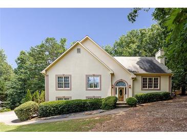 Charming traditional-style home with an arched entryway and manicured landscaping at 629 Pine Ter, Canton, GA 30114