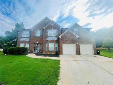 Traditional brick home with a well-manicured lawn, attached garage, and a welcoming entrance on a sunny day at 2545 Melville Pl, Powder Springs, GA 30127