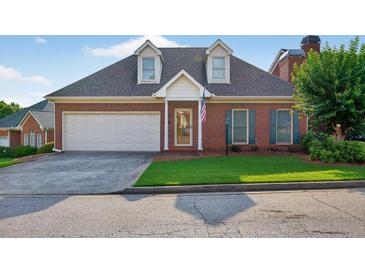 Charming brick home featuring a two-car garage, well-manicured lawn, and an inviting front entrance at 2000 Stockton Walk Ln, Snellville, GA 30078