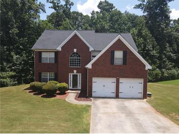 Charming two-story red brick home featuring a two-car garage and well-manicured lawn at 856 Haydens Rdg, Ellenwood, GA 30294