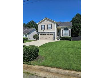 Charming two-story home features a manicured lawn, attached two-car garage and mature trees at 4209 Resheemah St, Atlanta, GA 30349