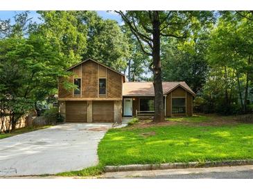 Charming home featuring mature trees, a two-car garage, and a well-maintained front lawn at 340 Windsor Se Walk, Conyers, GA 30094