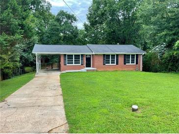 Charming brick home with well-maintained lawn and a covered carport at 25 Gladstone Sw Dr, Marietta, GA 30060