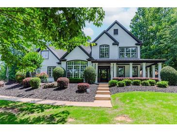 Stunning two-story home boasting a modern black and white exterior, complemented by a beautifully landscaped front yard at 2373 Oak Falls Ln, Buford, GA 30519