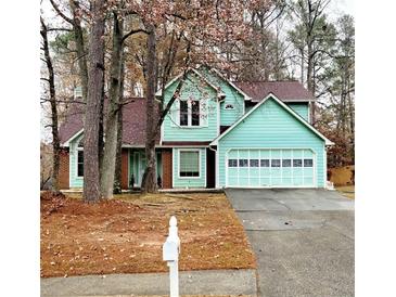 Charming two-story home featuring a light blue exterior and attached two-car garage at 1034 Bettina Sw Ct, Mableton, GA 30126