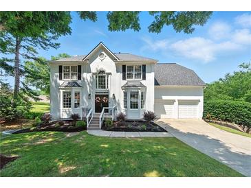 Charming white two-story home with a well-manicured lawn and attached two car garage at 312 Laurel Run Cv, Sugar Hill, GA 30518