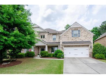Two-story brick home featuring an attached two-car garage and a well-manicured front lawn at 2535 Castlerock Ct, Cumming, GA 30041