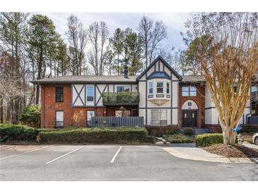 Charming exterior view of townhome with brick accents, balcony, and manicured landscaping for curb appeal at 6851 Roswell Rd # L1, Atlanta, GA 30328