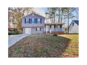 Split-level home with a covered front porch, driveway, and lawn at 4185 Duesenberg Dr, Tucker, GA 30084