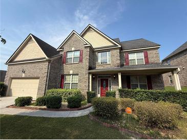 Two-story brick home with red shutters, covered front porch, manicured lawn and landscaping at 3139 Tuscan Ridge Dr, Snellville, GA 30039