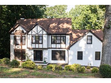 Charming Tudor style home with white exterior, dark trim, and well-manicured landscaping at 4640 Calleigh Way, Snellville, GA 30039