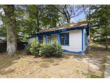 Charming home with light siding, blue trim, and a cozy front yard with mature trees and bushes at 1321 Mcclelland Ave, Atlanta, GA 30344