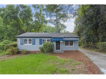 Charming single-story home featuring light gray siding, blue shutters, and a cozy front yard with mature trees at 2436 Clarissa Nw Dr, Atlanta, GA 30318