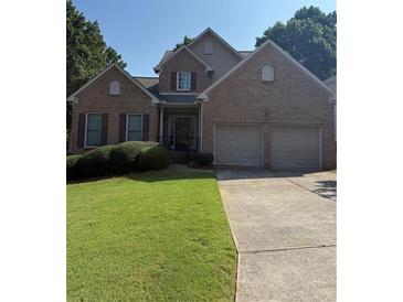 Charming two-story brick home featuring an attached two-car garage and well-manicured lawn at 2580 Three Wood Dr, Villa Rica, GA 30180