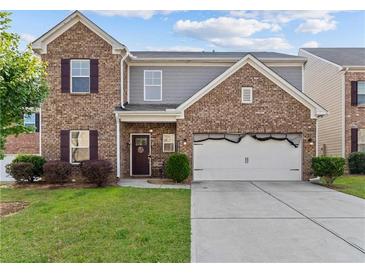 Charming two-story brick home with a well-manicured lawn and an attached two-car garage at 1742 Weatherbrook Cir, Lawrenceville, GA 30043