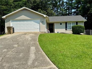 Charming one story home featuring a two-car garage, well-maintained lawn and a mature tree line at 5709 Buck Ct, Ellenwood, GA 30294