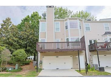 Exterior view of a townhome featuring a two-car garage, a balcony, and neutral-colored siding at 3761 Lake Point Blvd, Suwanee, GA 30024