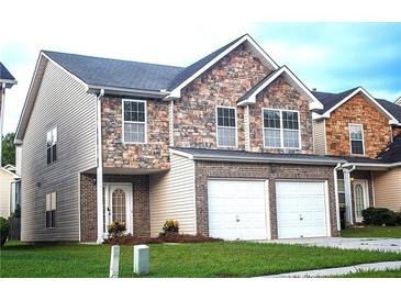 Charming two-story home with a stone facade and a two-car garage, set on a well-maintained lawn at 8838 Seneca Rd, Palmetto, GA 30268