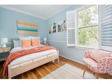 Bright bedroom with light blue walls, wood floors, and a large window letting in natural light at 200 B Reinhardt Se St, Atlanta, GA 30312