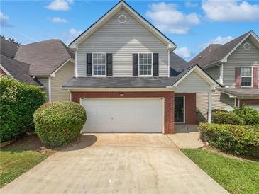 Charming two-story home features a two-car garage, brick accents, and a well-manicured lawn at 509 Carlton Pointe Dr, Palmetto, GA 30268