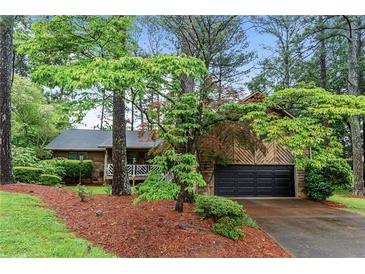 Charming home featuring wood siding, well-manicured landscaping, and an attached two-car garage at 490 Hunters Glen Ct, Lawrenceville, GA 30044