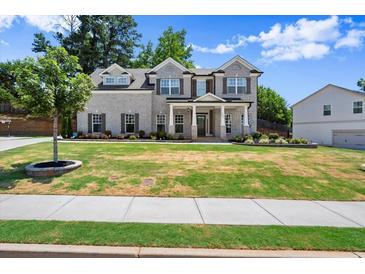 Beautiful two-story home boasts a well-manicured lawn and brick and siding exterior with stately front columns at 1620 Brook Ivy Dr, Lawrenceville, GA 30044