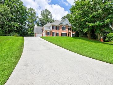 Beautiful two-story home with a long driveway and well-maintained lawn and mature trees at 4221 Bretdale Nw Run, Kennesaw, GA 30152