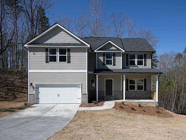Charming two-story home with a covered porch, attached garage, and well-manicured lawn on a sunny day at 250 Shawnee Trl, Dallas, GA 30157