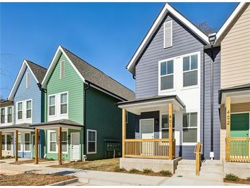 Colorful new construction townhomes with individual front porches and modern design elements, set against a clear blue sky at 1095 Tucker Ave # 401, Atlanta, GA 30310