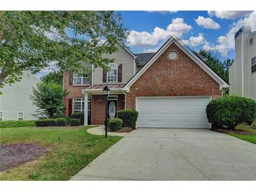 Charming two-story home featuring a brick facade, attached two-car garage, and well-manicured lawn at 2421 Fall Creek Lndg, Loganville, GA 30052