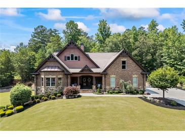 Beautiful brick home with manicured lawn and mature trees, featuring a covered front porch and lush landscaping at 1005 Renfroe Lake Dr, Auburn, GA 30011