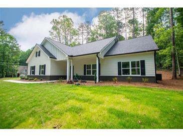 Beautiful one-story home with a white exterior, black shutters and large front yard at 5525 Belle Meade Dr, Villa Rica, GA 30180