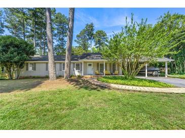 Charming single-story home with a welcoming front porch, lush lawn, and convenient carport in a tranquil setting at 1444 Arden Sw Dr, Marietta, GA 30008