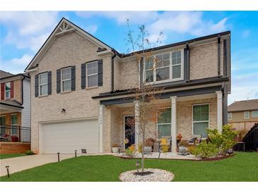 Charming two-story brick home with attached garage and a well-manicured front yard at 7246 Gladstone Cir, Lithonia, GA 30038