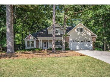 Charming home with a well-manicured lawn and lush greenery, featuring a two-car garage and inviting front porch at 2130 Hampton Se Trl, Conyers, GA 30013