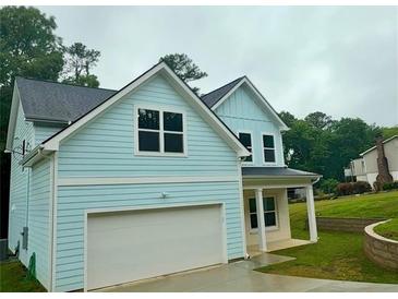 Charming two-story home featuring blue siding, a garage, and a well-manicured front lawn at 5341 Stewart Mill Rd, Douglasville, GA 30135
