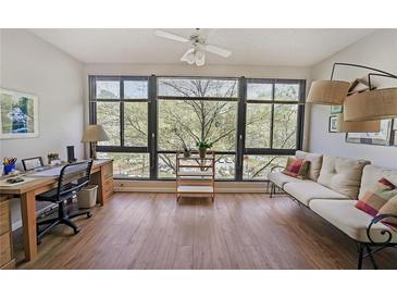 Bright living room features hardwood floors, large windows, and a cozy seating area with natural light at 1800 Clairmont Lk # 427, Decatur, GA 30033