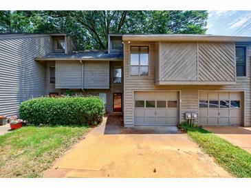Charming townhouse with a two-car garage and lush green landscaping at 1002 Creatwood Se Cir, Smyrna, GA 30080