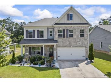Charming two-story brick home with a well-manicured lawn and inviting front porch at 2260 Cedar Place Ct, Snellville, GA 30078