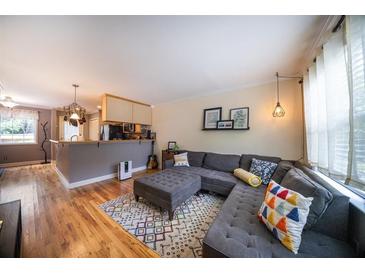 Inviting living room showcasing a comfortable gray sectional sofa, hardwood floors, and modern decor at 2232 Dunseath Ave # 407, Atlanta, GA 30318
