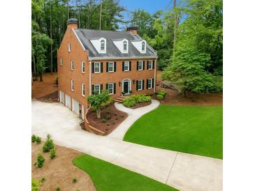 Beautiful brick two-story home featuring mature trees, a well-manicured lawn, and a three-car garage at 4250 Green Ridge Ne Dr, Marietta, GA 30062