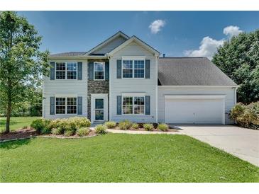 Charming two-story home featuring stone accents, a well-manicured lawn, and an attached two-car garage at 7550 Springmill Ct, Cumming, GA 30028