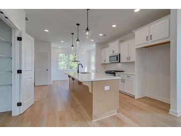 Bright kitchen features a large island, modern appliances, and hardwood floors at 1931 Deco Dr, Kennesaw, GA 30144