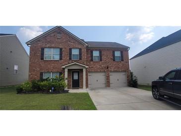 Charming two-story brick home featuring a well-manicured lawn and an attached two-car garage at 3484 Enterkin Ln, Atlanta, GA 30349